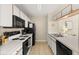 Efficient kitchen with white cabinetry and black appliances at 8716 Rain Forest Pl # D, Kissimmee, FL 34747