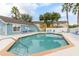 A community swimming pool with lounge chairs in a residential apartment complex on a bright sunny day at 8716 Rain Forest Pl # D, Kissimmee, FL 34747
