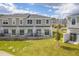 Rear view of townhomes, showing private patios and grassy areas at 2023 Claudia Ln, Kissimmee, FL 34741