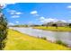 Scenic view of a green backyard sloping down to a tranquil lake on a sunny day at 2949 Nottel Dr, St Cloud, FL 34772