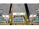 Aerial view of the home's back yard with in-ground pool enclosed by white screen, bordered by green grass at 8932 Cabot Cliffs Dr, Davenport, FL 33896
