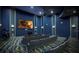 Private home theater featuring tiered seating, projector, and custom wall design at 8932 Cabot Cliffs Dr, Davenport, FL 33896