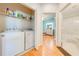Bright laundry room with a stacked washer and dryer, storage shelving, and easy access to bathroom and bedroom at 1819 Coriander Dr # 1819, Kissimmee, FL 34759
