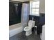 Bathroom with black tiled walls, a shower-tub combo, and updated fixtures at 20526 Quinella St, Orlando, FL 32833