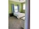 Bedroom with light green walls, carpet, and a window overlooking the backyard at 20526 Quinella St, Orlando, FL 32833