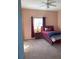Bedroom with carpeted flooring, peach walls, red bedding, and good natural light at 20526 Quinella St, Orlando, FL 32833