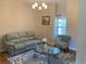 Cozy sitting room with a soft sofa, patterned chair, and an interesting glass top coffee table at 20526 Quinella St, Orlando, FL 32833
