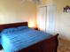 Bedroom with a queen bed, white closet doors, and a charming cuckoo clock at 101 Whitehall Way, Kissimmee, FL 34758
