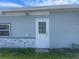 Exterior back view of the home featuring a door and decorative stone accents at 7024 Moderna Way, Orlando, FL 32822