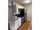 Compact kitchen featuring stainless steel appliances, granite counters, and white cabinetry at 7024 Moderna Way, Orlando, FL 32822