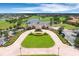 Stunning aerial view of the community clubhouse, golf course, and pond on a bright, sunny day at 13809 Abberwick Dr, Orlando, FL 32832