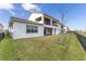 Backyard view of the house with a covered outdoor patio and a green lawn at 13809 Abberwick Dr, Orlando, FL 32832