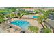 Aerial shot of a vibrant community pool area with splash pad, seating, and playground at 13809 Abberwick Dr, Orlando, FL 32832