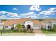 Charming single-Gathering home featuring a red-tiled roof, arched entryway, two-car garage, and lush landscaping at 13809 Abberwick Dr, Orlando, FL 32832