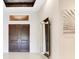 Grand foyer featuring a dark wood double-door, a modern mirror, and neutral wall art at 13809 Abberwick Dr, Orlando, FL 32832