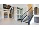 Elegant foyer featuring a staircase, wine cellar, custom art displays, and dark wood double-doors at 13809 Abberwick Dr, Orlando, FL 32832