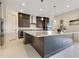 Kitchen island with modern pendant lighting and stainless steel appliances makes a functional and stylish focal point at 13809 Abberwick Dr, Orlando, FL 32832