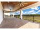 Covered outdoor patio with stone flooring, ceiling fans and black railing overlooking nature at 13809 Abberwick Dr, Orlando, FL 32832