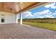 Covered outdoor patio with stone flooring, ceiling fans and overlooking green grass at 13809 Abberwick Dr, Orlando, FL 32832