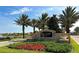 Elegant community entrance sign featuring 'Eagle Creek' surrounded by palm trees and colorful landscaping at 13809 Abberwick Dr, Orlando, FL 32832