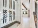A walk in glass enclosed wine cellar with display racks on the right, and a glimpse of the dining area at 13809 Abberwick Dr, Orlando, FL 32832