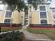 A low angle view shows the apartment building's exterior with balconies and manicured landscaping at 8910 Legacy Ct # 206, Kissimmee, FL 34747