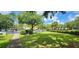 Well-manicured front lawn with lush green grass, mature trees, and landscaping in a sidewalk community at 8910 Legacy Ct # 206, Kissimmee, FL 34747
