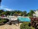 Resort-style community pool with colorful cabanas, lounge chairs, and lush tropical landscaping at 8910 Legacy Ct # 206, Kissimmee, FL 34747