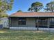 View of the backyard showing the screened-in porch and an AC unit at 98 Pine Island Cir, Kissimmee, FL 34743