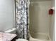 Cozy bathroom featuring a tub/shower with zebra-themed curtain and neutral tilework at 98 Pine Island Cir, Kissimmee, FL 34743