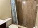 Tiled shower with decorative curtain and neutral color palette in this renovated bathroom at 98 Pine Island Cir, Kissimmee, FL 34743
