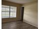 Bedroom features a large window and wood-look floors and a view to the outside at 98 Pine Island Cir, Kissimmee, FL 34743