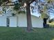 Exterior of home with bright green lawn and large tree in the yard at 98 Pine Island Cir, Kissimmee, FL 34743