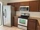 Kitchen with stainless steel appliances, including a refrigerator, microwave, and oven at 98 Pine Island Cir, Kissimmee, FL 34743