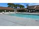 Community pool with lounge chairs, tables, and landscaping at 98 Pine Island Cir, Kissimmee, FL 34743