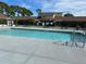 Community pool with lounge chairs, tables, and landscaping at 98 Pine Island Cir, Kissimmee, FL 34743
