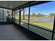 View from the screened porch showing the lawn, trees, and a lake at 98 Pine Island Cir, Kissimmee, FL 34743