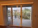 Sliding glass doors reveal a view of a water feature and treetop landscape from private balcony at 13838 Fairway Island Dr # 1432, Orlando, FL 32837