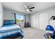 Neutral-toned bedroom features a ceiling fan, window overlooking greenery, and a double door closet at 392 Winter Ridge Blvd # 105, Winter Haven, FL 33881