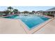 Spacious community pool offers ample swimming space, surrounded by lounge chairs, and a safety fence at 392 Winter Ridge Blvd # 105, Winter Haven, FL 33881