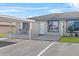 Charming condo with blue trim and outdoor patio area, complemented by an adjacent covered parking space at 392 Winter Ridge Blvd # 105, Winter Haven, FL 33881
