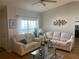 Cozy living room with two sofas, window, and hardwood flooring at 5062 El Destino Dr, Leesburg, FL 34748