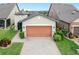 House exterior with orange garage door and landscaping at 516 Pamplona Pl, Davenport, FL 33837