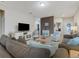 Bright living room with comfy sofas, coffee table, and view into kitchen at 516 Pamplona Pl, Davenport, FL 33837