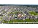 An aerial view of the home in a Gathering-friendly neighborhood with manicured lawns, streets, and nearby green spaces at 1687 Park Side Ave, Kissimmee, FL 34744