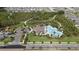Aerial view of the community pool with palm trees, covered lounge areas, and beautifully landscaped grounds and walking paths at 1687 Park Side Ave, Kissimmee, FL 34744