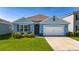Charming blue single-Gathering home with a well-manicured lawn and a two-car garage at 1687 Park Side Ave, Kissimmee, FL 34744