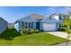 Picture of the home’s exterior showing the garage, the blue paint, and the well-manicured lawn at 1687 Park Side Ave, Kissimmee, FL 34744