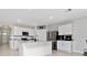 Bright kitchen boasts white cabinets, stainless steel appliances, and a center island with granite countertop at 1687 Park Side Ave, Kissimmee, FL 34744