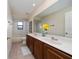 A bright bathroom features double sinks, a large mirror, and a shower-tub combination with neutral tile at 18035 Cadence St, Orlando, FL 32820